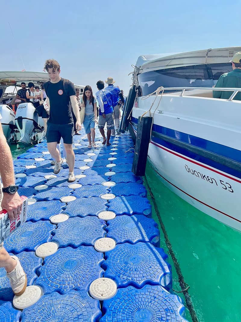 Passengers stepping off a speedboat onto the floating pier at Koh Lipe